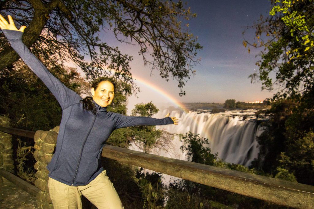 Photographer capturing Victoria Falls from a viewpoint in Livingstone, Zambia